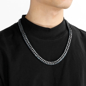 Gros plan d'un collier chaîne gourmette en acier inoxydable gris porté par un mannequin