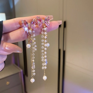 Close-up of dangling butterfly tassel earrings with pink crystals and white pearls