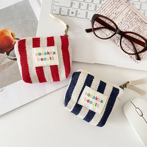 Detailed top view of striped canvas mini storage bags for makeup and coins on a desk