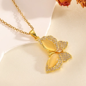 Detail of gold bow necklace with yellow cat eye stone and micro-inlaid zircons