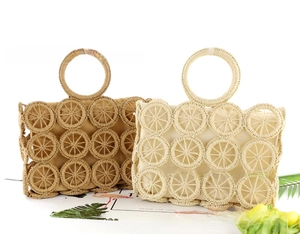 Detail of hand-woven straw bags with circular hollow patterns and round handles for summer