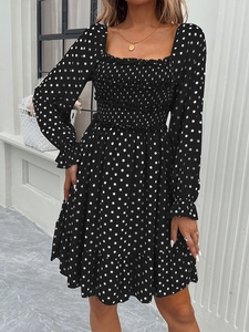 Detail view of the black polka dot dress with shirred waist and ruffled sleeve cuffs