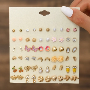 Close-up of 30 pairs assorted stud earrings set with pearls and rhinestones on card