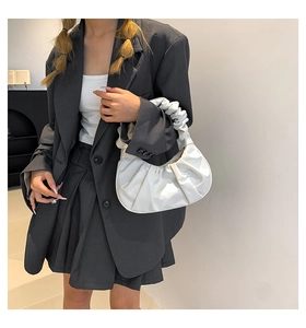 Detail of white pleated cloud bag showing soft leather texture and stylish ruched handle
