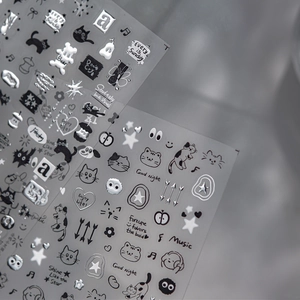 Detail of embossed black cat nail stickers with silver stars and musical note patterns