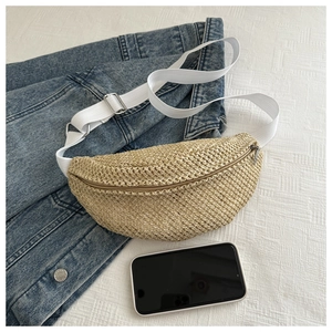 Détail du mini sac banane en paille tressée avec sangle blanche et zip en argent poli