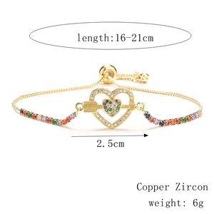 Detail view of heart-shaped gold bracelet with rainbow zircon and adjustable dimensions