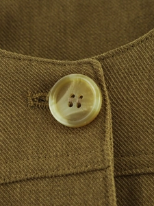 Detailed macro view of four-hole resin buttons on olive green twill cotton jacket fabric