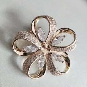 Gros plan d'une broche fleur dorée avec zircons incrustés et design détaillé à cinq pétales