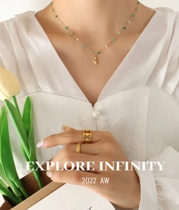Macro shot of tulip flower pendant necklace with green crystal beads and gold rings