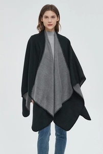 Detail of black and grey reversible cashmere poncho with intricate blanket stitching