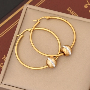 Close-up of golden stainless steel hoop earrings with a sparkling rhinestone-set bead