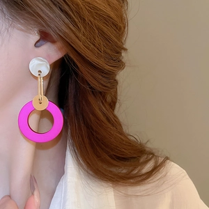 Detail of creative geometric earrings with pink frosted ring and marble stud on model