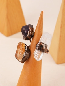 Macro detail of dark punk rings with raw crystals and vintage bronze plating
