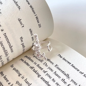 Irregular 925 sterling silver lava texture ring placed on an open book page
