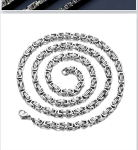 Macro shot of silver titanium steel Byzantine chain with lobster clasp on white background