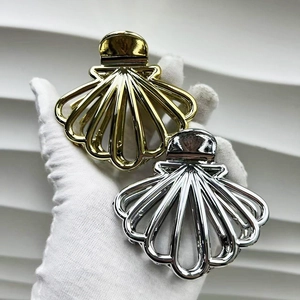 Detail view of shell-shaped metal hair claws in gold and silver finish with hollow design