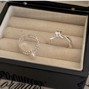 Close-up of S925 sterling silver knot ring and pearl ring in jewelry box