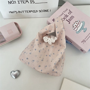 Detailed shot of pink floral canvas bag with white lace trim and blue flower patterns