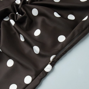 Gros plan sur la texture du tissu à pois et la fermeture éclair invisible de la robe