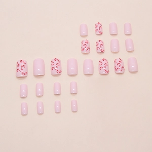 Pink polka dot press-on nails with Christmas candy cane patterns in a 24-piece set