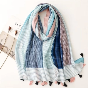 Detail of light cotton-linen scarf with blue stripes and heart patterns and fringe