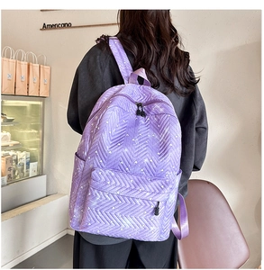 Mochila acolchada morada con estampado de corazones y correas ajustables en un café