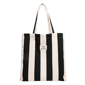 Minimalist black and white striped canvas tote bag with woven label and modern design