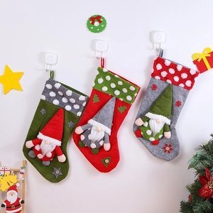 Three Christmas gnome stockings in red, green, and gray colors for festive tree decoration