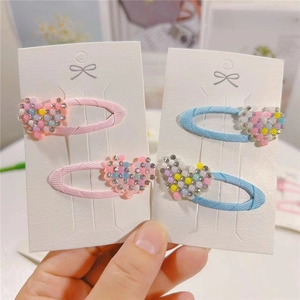 Close-up of pink and blue rhinestone heart hair clips for girls on display cards