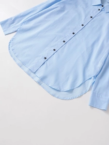 Camisa de manga larga azul claro con pliegues y dobladillo curvo en vista plana