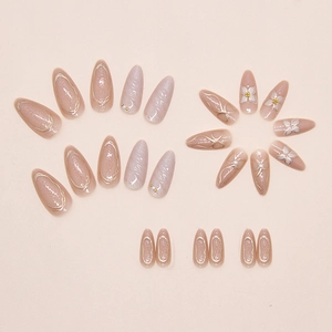Detailed view of 3D embossed floral nail art with pearls and gold bow accents