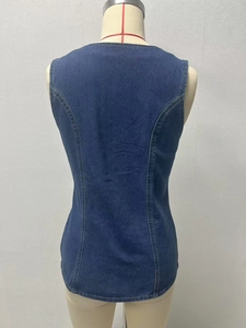 Detail view of dark blue denim vest back showing waist cut and double-stitch texture