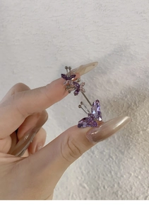 Détail de la bague d'oreille papillon en cristal violet avec finition argentée