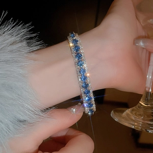 Close-up of sparkling blue and silver diamond bracelet on wrist with elegant fur detail