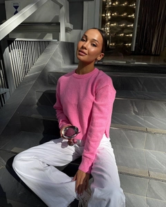 Detailed texture of bright pink round neck knit sweater paired with white wide-leg trousers
