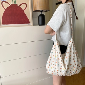Detail of white canvas tote bag with floral teddy bear print for daily commuting