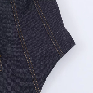 Detailed macro view of dark indigo denim fabric with yellow double contrast stitching