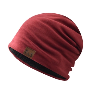 Gros plan d'un bonnet slouchy bordeaux avec doublure polaire noire et écusson.