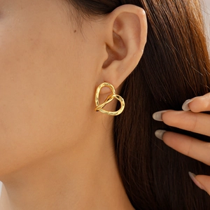Close-up of model wearing 18k gold plated heart-shaped twisted hollow earrings