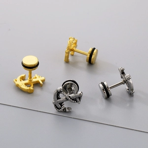 Vista macro di orecchini a perno ad ancora in oro e argento dallo stile punk vintage
