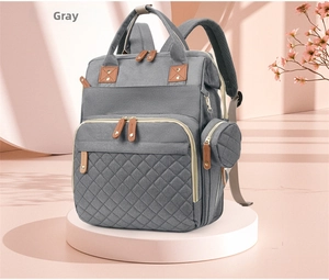 Detail of dark grey stylish diaper backpack with quilted front pocket on soft pink display