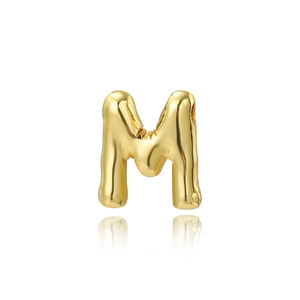 Close-up of polished 18K gold plated letter M pendant with high gloss finish and reflection