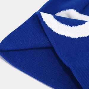 Detailed macro view of the royal blue knitted beanie showing white jacquard texture