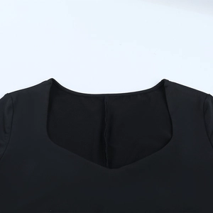 Detailed close-up of the square neckline and elegant mesh stitching on the black dress