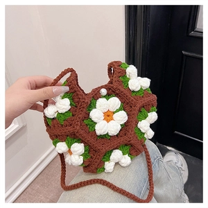 Detail of handmade crochet shoulder bag featuring 3D daisies and elegant pearl closure
