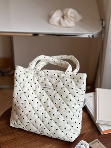 Détail du sac cabas matelassé en velours côtelé blanc avec imprimés cœurs noirs