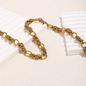 Detail of 18K gold plated stainless steel chunky chain necklace on textured surface