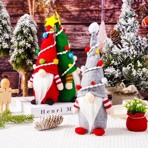 Three festive Christmas gnomes with grey red and green hats on a cozy wooden background