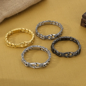 Close-up of vintage engraved Cuban link bracelets in gold silver and black finishes